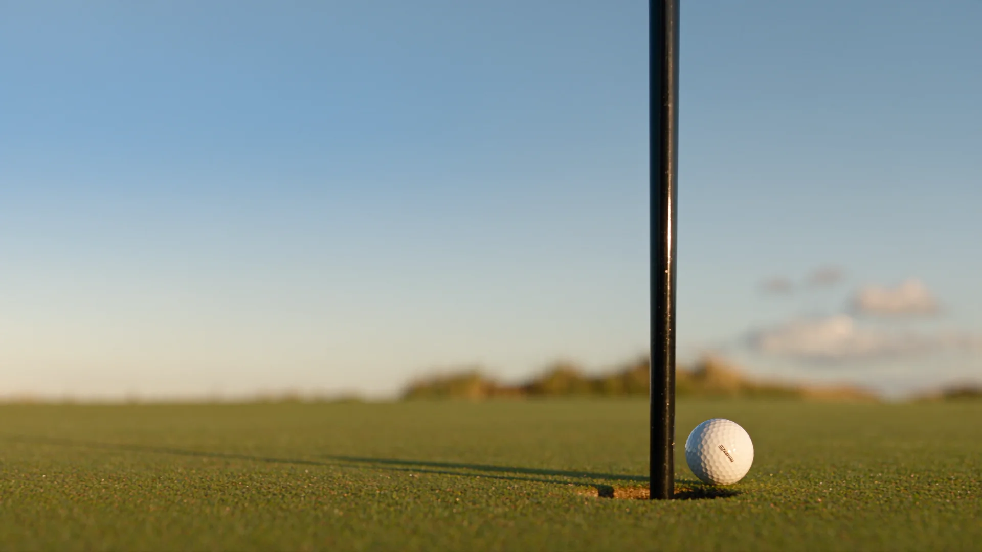 A golf ball resting inches from the hole after a bunker shot